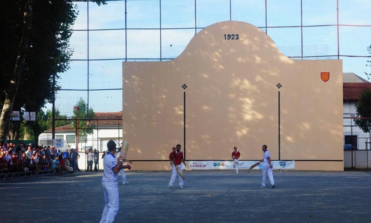 A sports field with a large wall displaying the year 1923 and a logo.