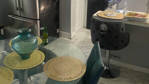 A modern kitchen with a refrigerator, stove, and dining table with chairs. - Cozy 2-bedroom house in enchanting Newark with AC comfort for everyone. (Newark)