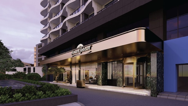 A modern hotel with a prominent Howard Johnson sign, a well-lit entrance, and a landscaped outdoor area. - HOWARD JOHNSON BY WYNDHAM TK Phnom Penh (Phnom Penh)