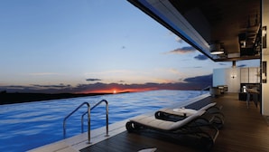 A modern outdoor pool area with lounge chairs and a sunset view. - HOWARD JOHNSON BY WYNDHAM TK Phnom Penh (Phnom Penh)