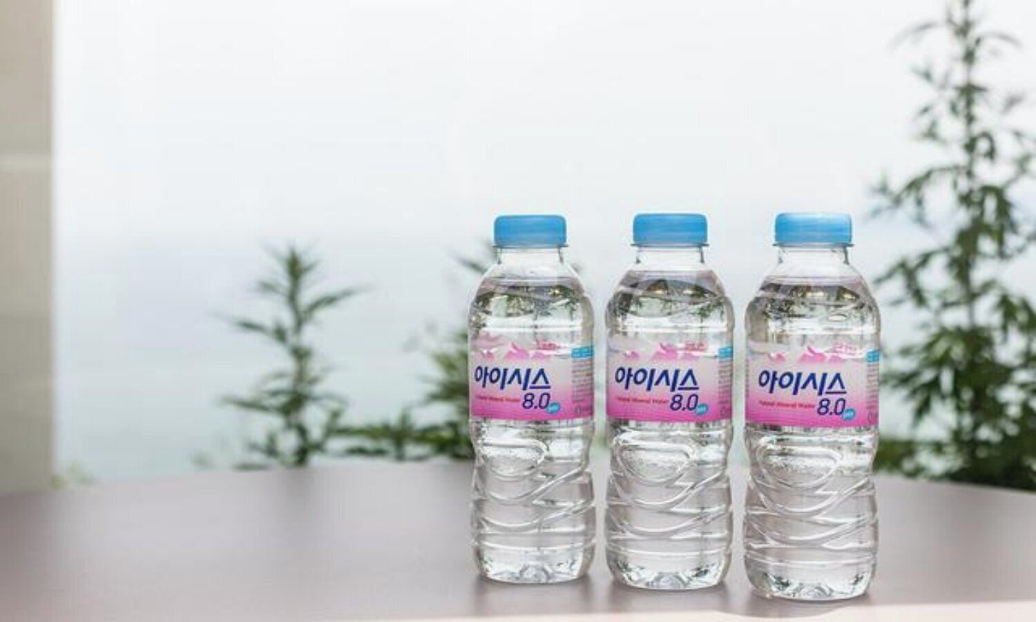 Tres botellas de agua con etiquetas sobre una mesa.
