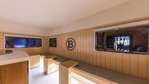 A compact, modern interior with a wooden finish, a bench, a small table, and a window with a view.