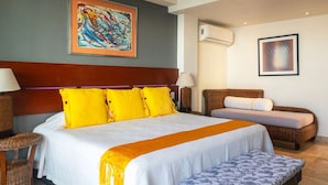 A hotel room with a large bed, a sofa, a bench, a painting, and an air conditioning unit. - Condo Anclote in Corral del Risco (Punta de Mita)