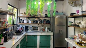 A compact kitchen with a microwave, toaster, and various appliances on the counter.