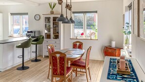 A modern kitchen with a dining area, wooden flooring, and large windows. - 2 bedroom awesome home in Faaborg (Faaborg)