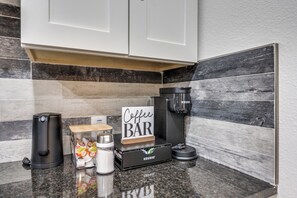 Eine Küche mit Kaffeebar, darunter ein Keurig-Kaffeemaschine, ein Schild mit der Aufschrift ‚Kaffeebar‘ und eine Keurig-Verpackung.