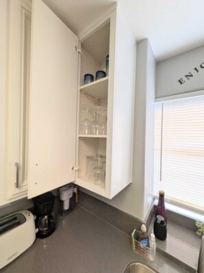 A kitchen with a cabinet, a toaster, a coffee maker, and a window with blinds. - 3 bedroom Condo ground floor 14 minutes from strip (Las Vegas)