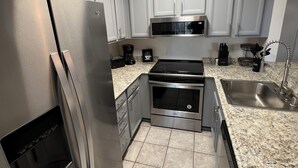 A modern kitchen with stainless steel appliances, a microwave, and a sink. - Tranquil 2-bedroom condo in San Diego perfect for your getaway (San Diego)