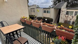 A balcony with a table and chairs, surrounded by potted plants. - Tranquil 2-bedroom condo in San Diego perfect for your getaway (San Diego)