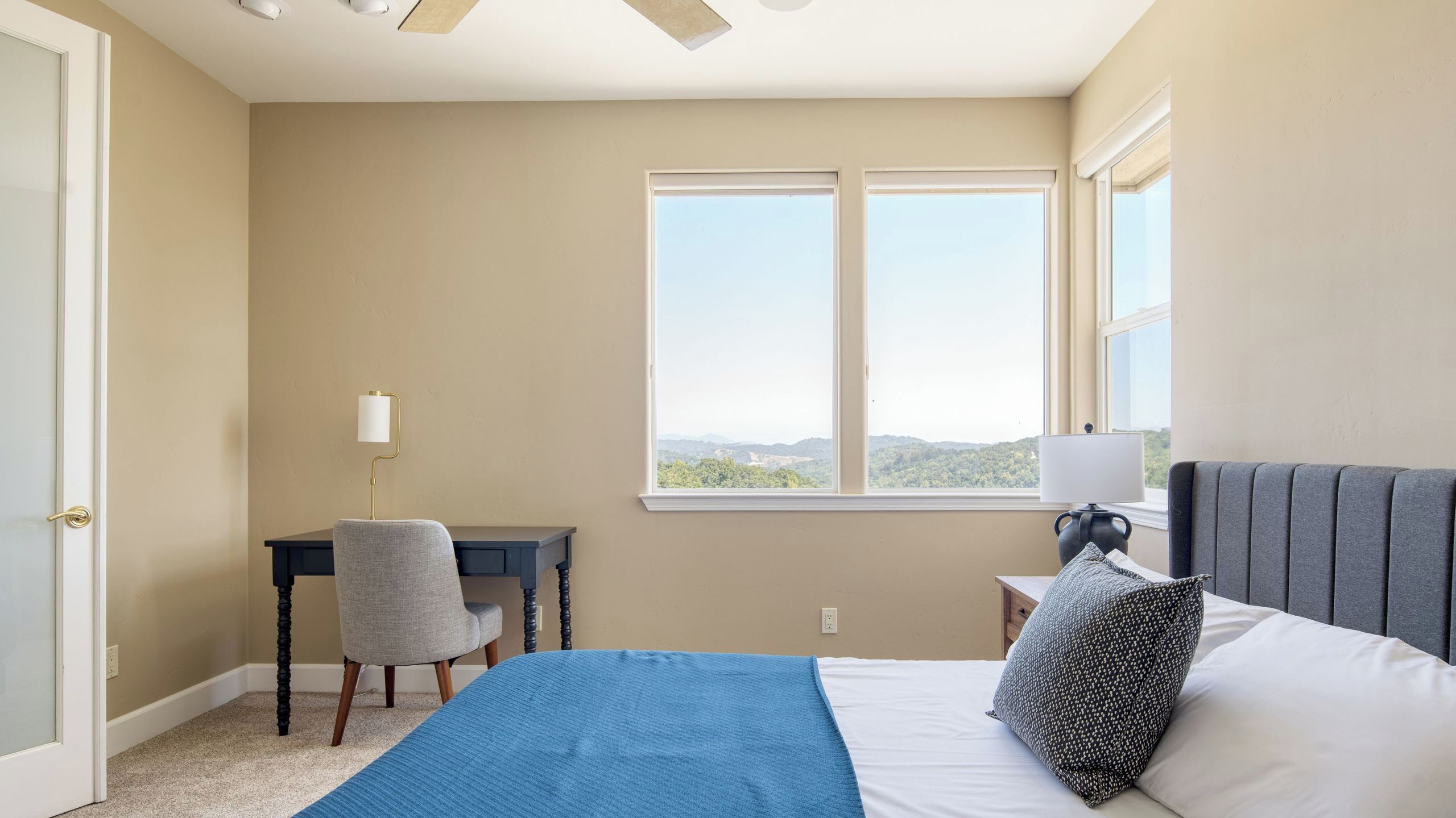 A bedroom with a bed, a desk, and a chair.
