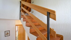 Una escalera de madera con barandilla que conduce a un piso superior.