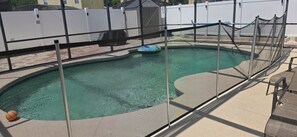 A swimming pool with a safety fence, a diving board, and a basketball on the edge. - Spacious 4-bedroom house in awesome Davenport with AC (Davenport)