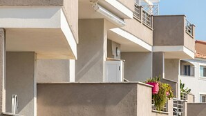 Un edificio residencial de varios pisos con balcones, techo plano y estilo arquitectónico moderno.