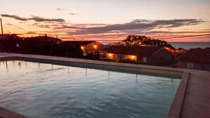 Una piscina con vistas a una colina y casas al fondo.