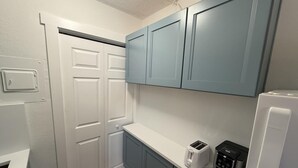 A kitchen with white and blue cabinets, a white countertop, a toaster, and a coffee maker. - Venice Villas Studio - Beachside - Pool (Venice)