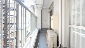 Ένας στενός διάδρομος με μεταλλικό προστατευτικό, μια εξωτερική σκάλα διαφυγής και ένα κουτί με ηλεκτρικέ ς συνδέσεις.
