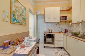 A kitchen with a microwave, oven, and various food items on the counter.
