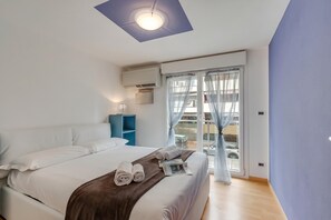 A hotel room with a bed, a nightstand, a lamp, and a view of the outside. - Clementines 50 Meters From Sea, Roquebrune-Cap-Martin, France (Roquebrune-Cap-Martin)