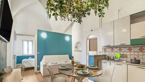 Un interno moderno con zona pranzo, cucina e camera da letto.