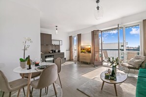 A modern apartment with a dining area, kitchen, living room, and balcony. - Glamour Apartment - Near Beach, Juan les Pins, France (Juan les Pins)