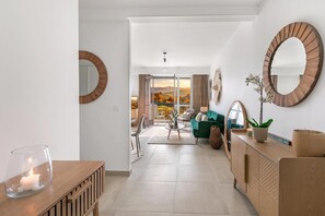 A modern living room with a green sofa, a wooden cabinet, and a large mirror. - Glamour Apartment - Near Beach, Juan les Pins, France (Juan les Pins)