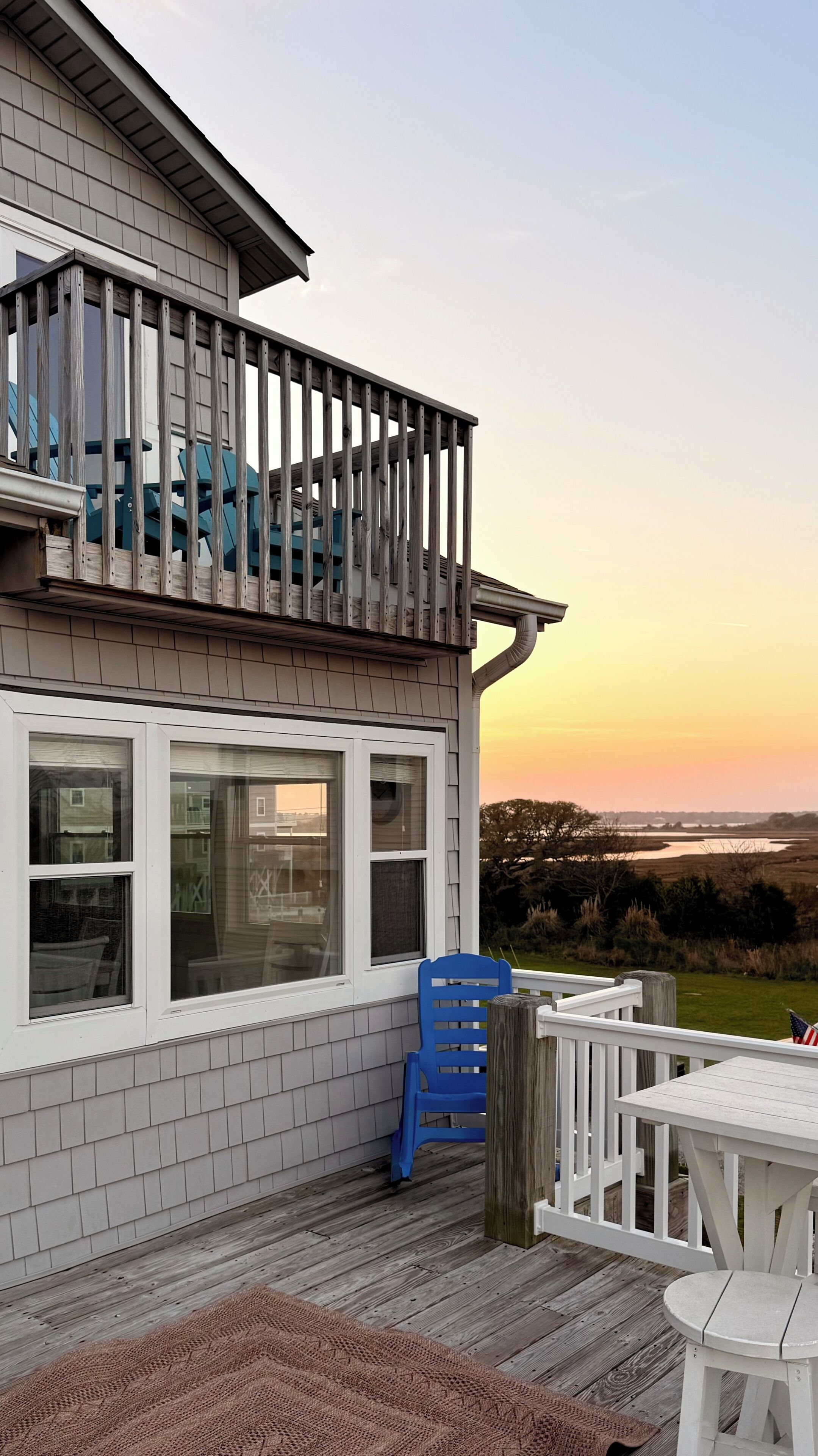 A house with a balcony, a view of the landscape, and outdoor furniture.