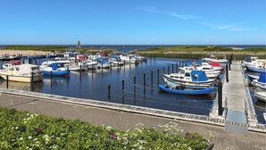 Un port de plaisance avec des bateaux amarrés, une jetée en bois et un ciel dégagé.
