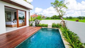 A modern house with a wooden deck, a swimming pool, and a view of the countryside. - Mountain Sunshine Private Villa (Sukawati)