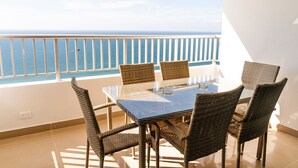 A balcony with a glass table and wicker chairs, overlooking the sea. - Playa Mar Beach (Cartagena)