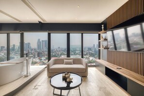 A high-rise apartment with a city view, a sofa, a coffee table, and a built-in shelf. - Departamento con tina al centro a min de Polanco (Ciudad de México)