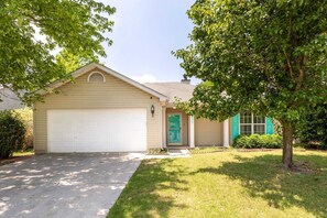 A single-story house with a garage, a front door, and a small porch.