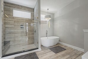 A modern bathroom with a glass shower enclosure, a freestanding bathtub, and a pendant light. - New 5BR Indy Game House -Near Fountain Sq - Sleeps 16 (Indianapolis)