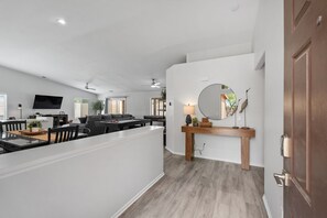 Ein stilvoller Wohnbereich mit Esstisch, Sofa und Wand-Fernseher.