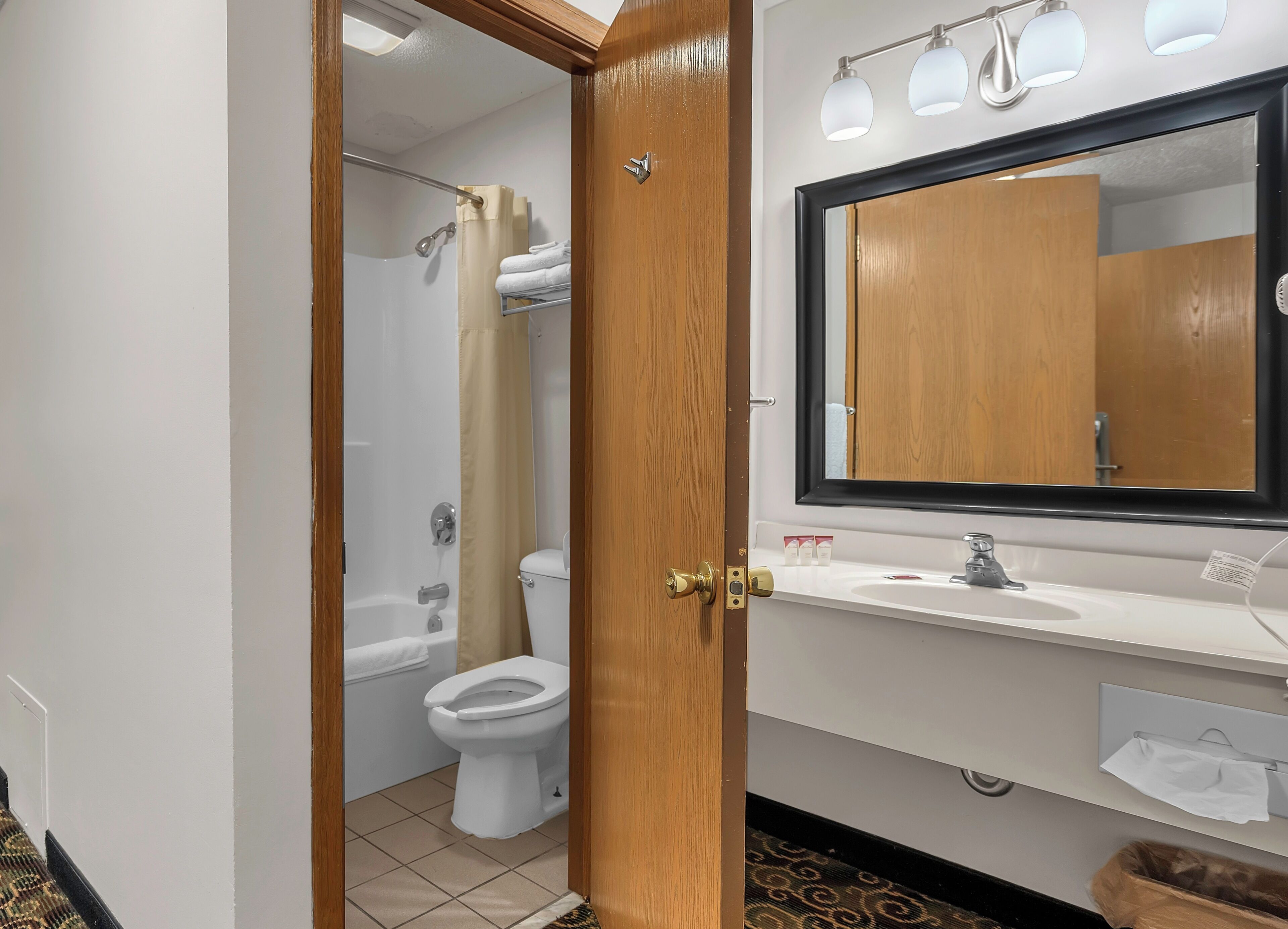 A bathroom with a toilet, shower, and sink.