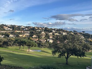 Ein Golfplatz mit Blick auf eine Wohngegend an einem Hügel.