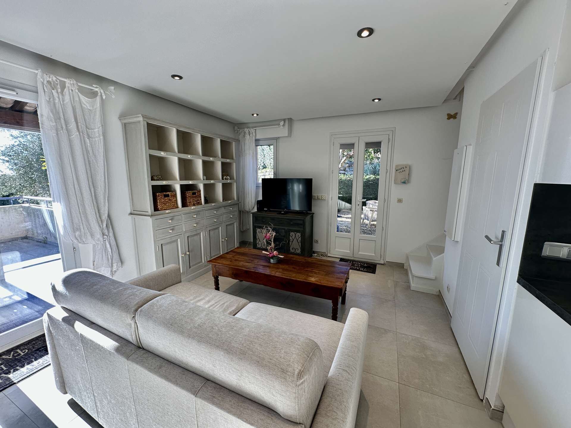 A living room with a sofa, TV, and built-in shelves.