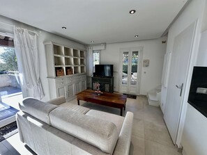 Ein Wohnzimmer mit Sofa, Fernseher und Einbauschränken.