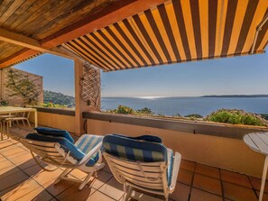 A terrace with a view of the sea, two lounge chairs, a table, and a pergola. - APARTMENT WITH PANORAMIC SEA VIEW (STE MAXIME)