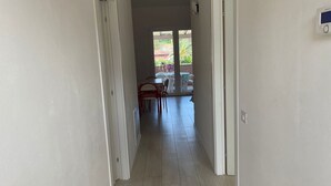 Un couloir menant à une salle à manger équipée de chaises et d’une table.