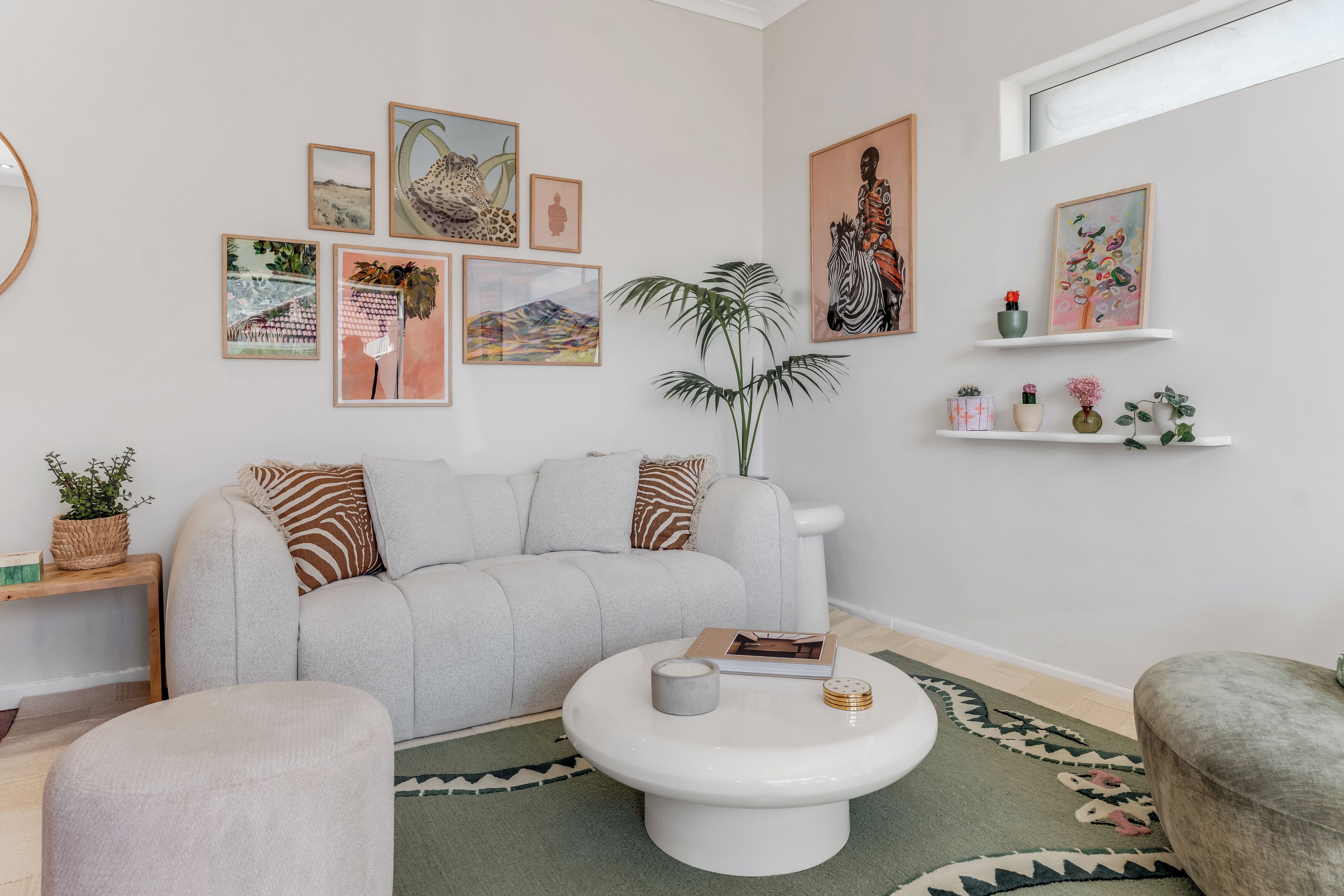 A modern living room with a sofa, coffee table, and artwork on the walls.