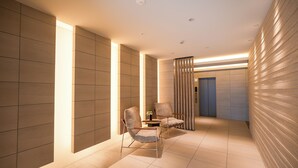 A modern interior with two chairs, a small table, and a decorative panel. - AYA RESIDENCE (Osaka)
