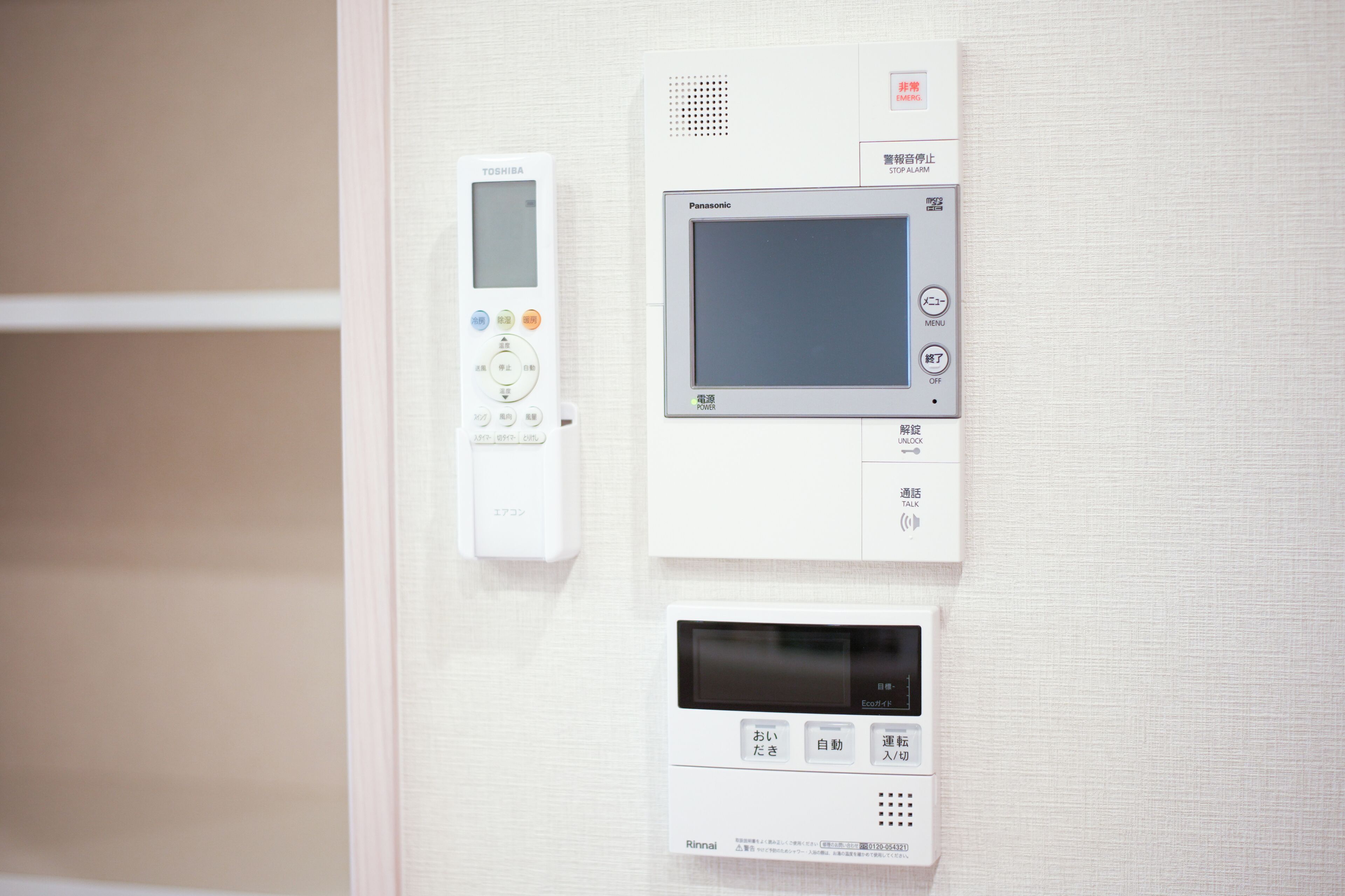 A wall-mounted control panel with a digital display, a keypad, and a speaker.