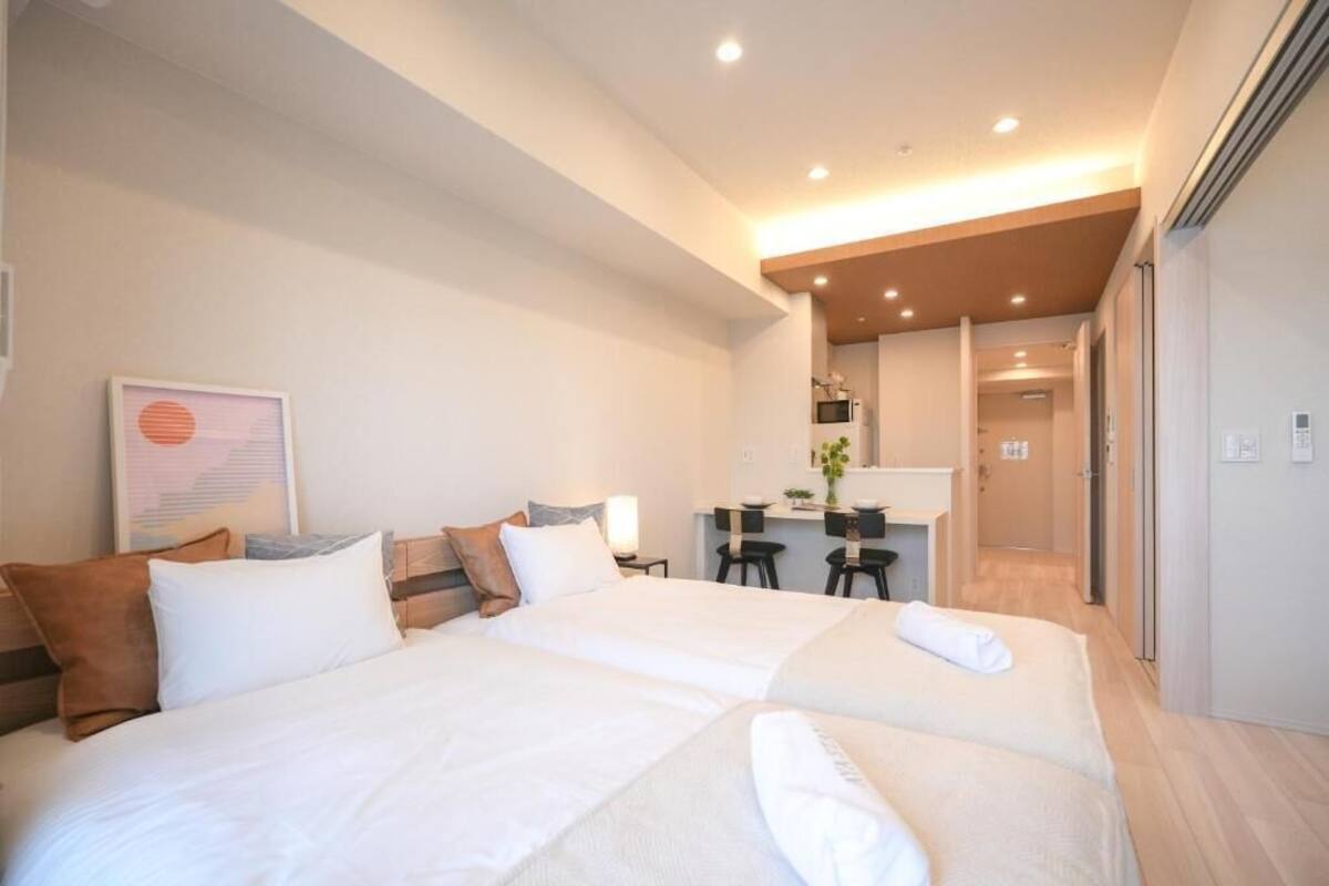 Une chambre d’hôtel avec un grand lit, un bureau et une kitchenette.