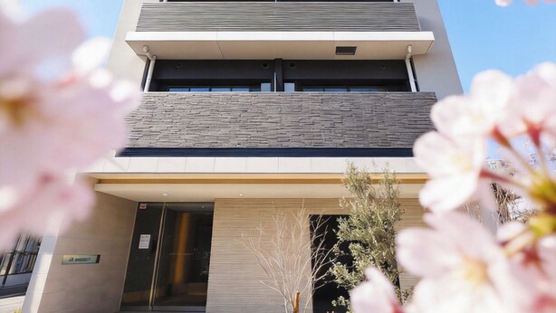 A multi-story building with a modern architectural design, featuring a series of balconies and a ground-level entrance. - AYA RESIDENCE (Osaka)