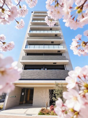 A multi-story building with a modern architectural design, featuring a series of balconies and a ground-level entrance. - AYA RESIDENCE (Osaka)