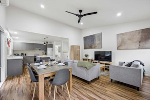 A modern apartment with a dining area, living room, and kitchen.