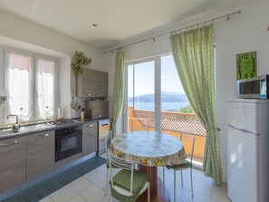 Eine Küche mit Esstisch und Stühlen, Meerblick und einem Balkon.