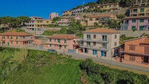 Um bairro residencial em encosta, com edifícios de vários andares, uma rua e áreas verdes.
