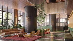 A lobby with a large seating area, a central column, and a plant. - 2BR Apt | Modern Amenities, Pool & Gym Near Casino (Southbank)