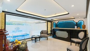 Eine Hotellobby mit Empfangsschalter, einer Lounge und einem großen Fenster mit Blick.